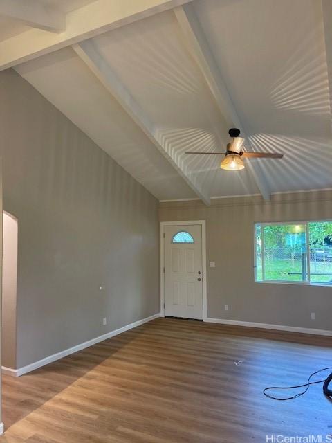 entryway with wood-type flooring, lofted ceiling with beams, and ceiling fan