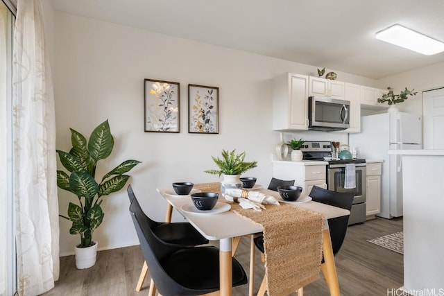 kitchen featuring white cabinets, stainless steel appliances, and dark wood-type flooring