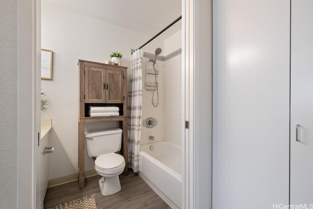 bathroom featuring hardwood / wood-style flooring, toilet, and shower / bathtub combination with curtain