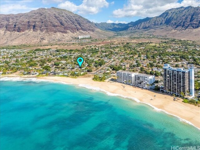 drone / aerial view featuring a view of the beach and a water and mountain view