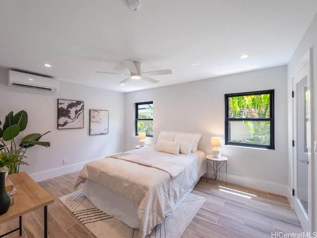 bedroom featuring a wall unit AC and ceiling fan