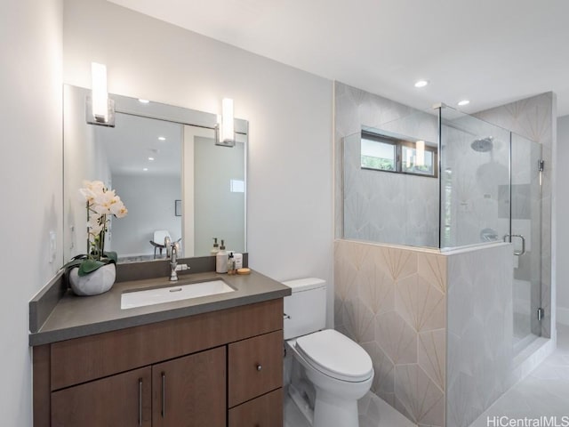 bathroom featuring vanity, a shower with shower door, and toilet