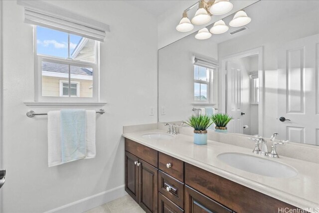 bathroom featuring toilet, vanity, tile patterned floors, and a healthy amount of sunlight