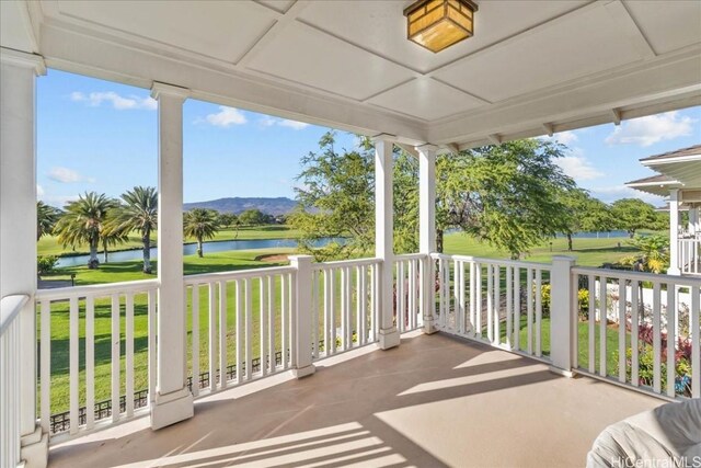 balcony with covered porch and a water view