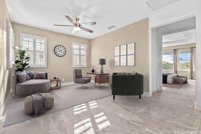 sitting room with ceiling fan and light carpet