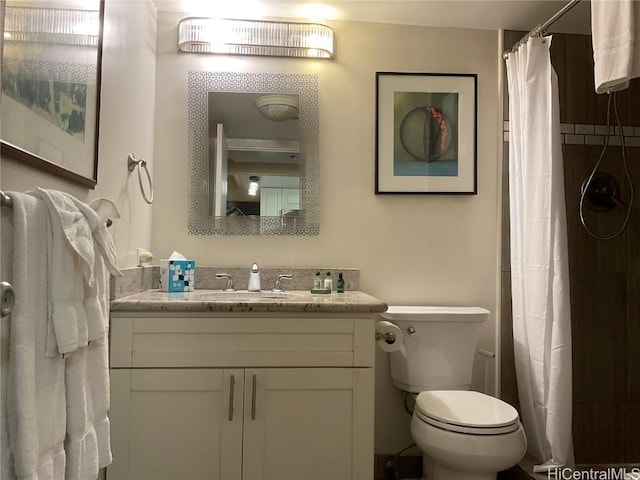 bathroom with curtained shower, vanity, and toilet