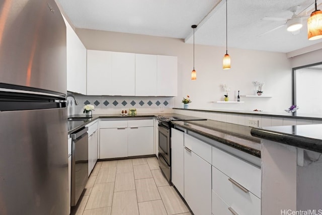 kitchen with pendant lighting, white cabinets, sink, tasteful backsplash, and stainless steel appliances