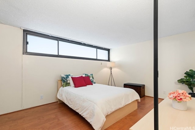 bedroom featuring wood-type flooring and a textured ceiling