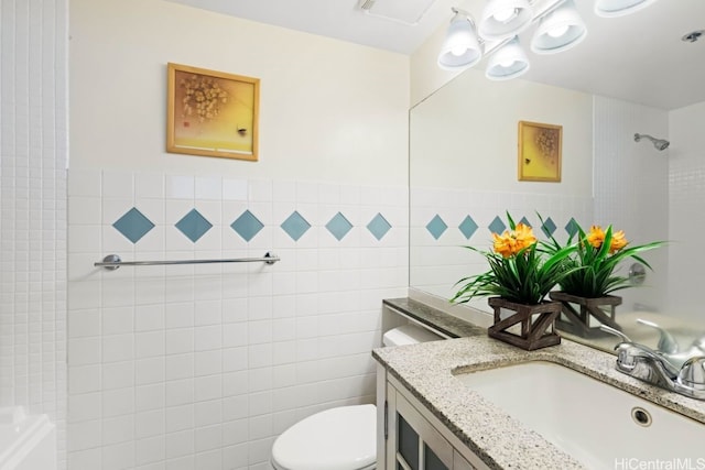 bathroom with vanity, tile walls, and toilet