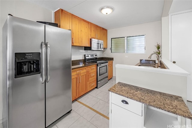 kitchen with stone counters, appliances with stainless steel finishes, decorative backsplash, and light tile patterned flooring