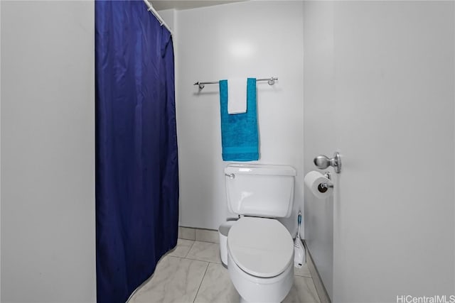 bathroom featuring walk in shower and toilet