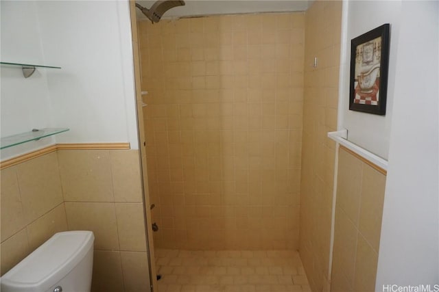 bathroom featuring tiled shower, tile walls, and toilet