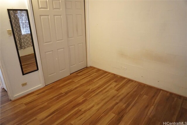 unfurnished bedroom with hardwood / wood-style floors and a closet