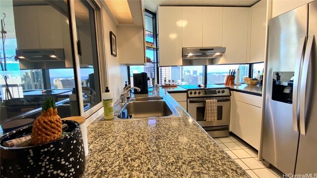 kitchen with white cabinetry, stainless steel appliances, sink, and light tile patterned floors