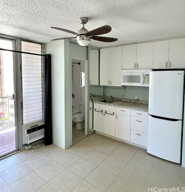 kitchen with ceiling fan, sink, a textured ceiling, white appliances, and white cabinets