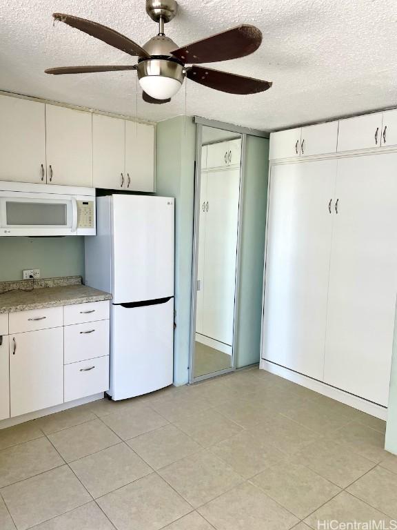 kitchen with ceiling fan, white cabinetry, white appliances, and a textured ceiling