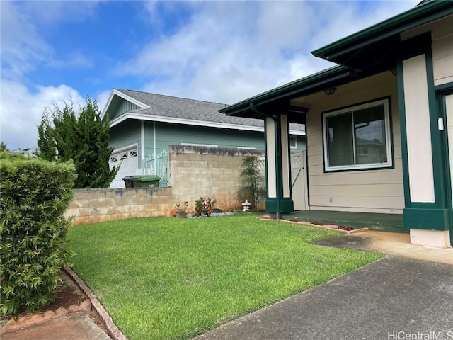 view of side of property featuring a lawn and a garage