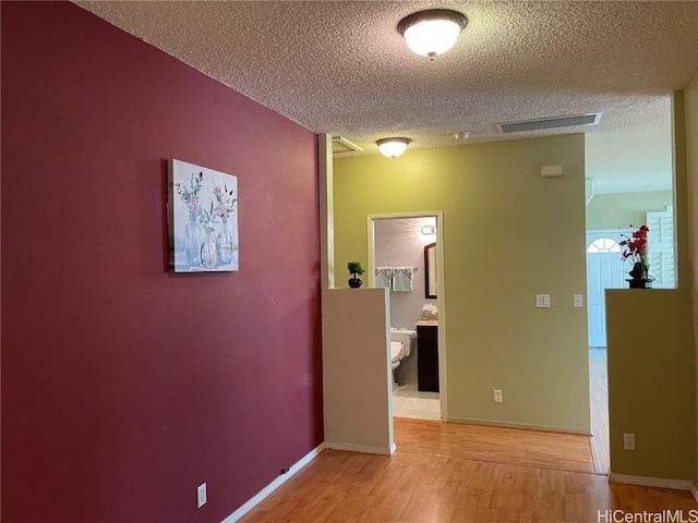 hall featuring wood-type flooring and a textured ceiling