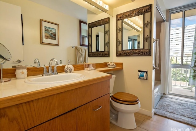 bathroom featuring tile patterned floors, vanity, toilet, and walk in shower