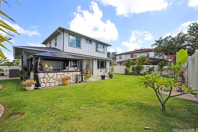 rear view of property with a gazebo and a lawn