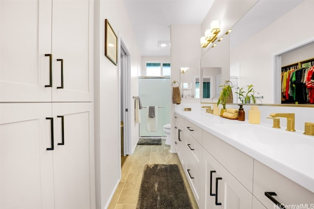 bathroom with vanity, a shower with shower door, and toilet