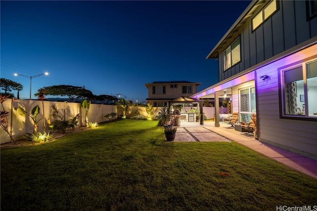 yard at night featuring a gazebo and a patio