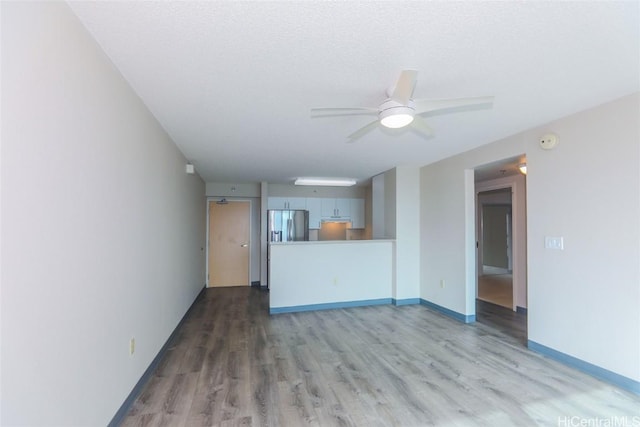 unfurnished living room featuring a textured ceiling, hardwood / wood-style flooring, and ceiling fan