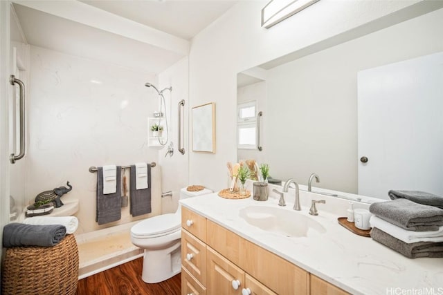 bathroom featuring walk in shower, hardwood / wood-style floors, vanity, and toilet