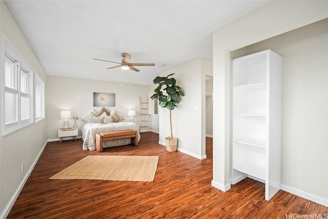 unfurnished bedroom with a textured ceiling, dark hardwood / wood-style floors, and ceiling fan