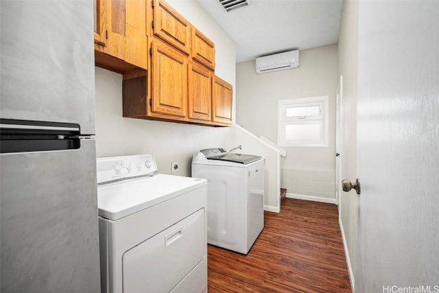 laundry area featuring dark hardwood / wood-style flooring, cabinets, a wall mounted AC, and washing machine and clothes dryer