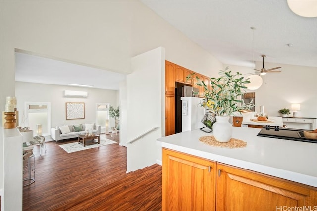 kitchen featuring a wall unit AC, stainless steel fridge, ceiling fan, and dark wood-type flooring