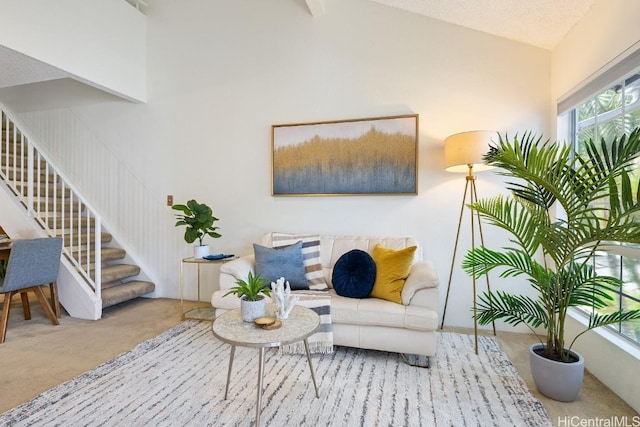 sitting room featuring light carpet and high vaulted ceiling