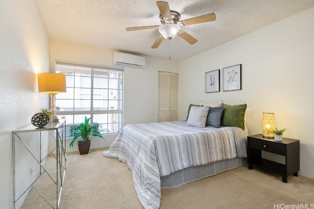 carpeted bedroom featuring ceiling fan, a textured ceiling, and a wall unit AC