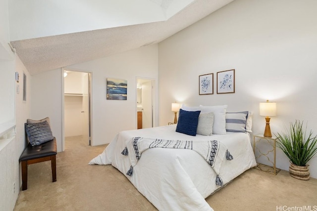 bedroom with carpet, a walk in closet, ensuite bath, a closet, and lofted ceiling