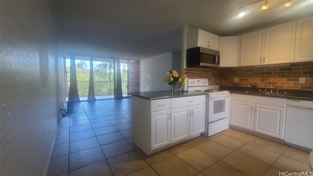 kitchen with kitchen peninsula, white appliances, white cabinetry, and sink