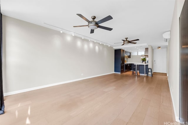 unfurnished living room featuring ceiling fan and light hardwood / wood-style flooring