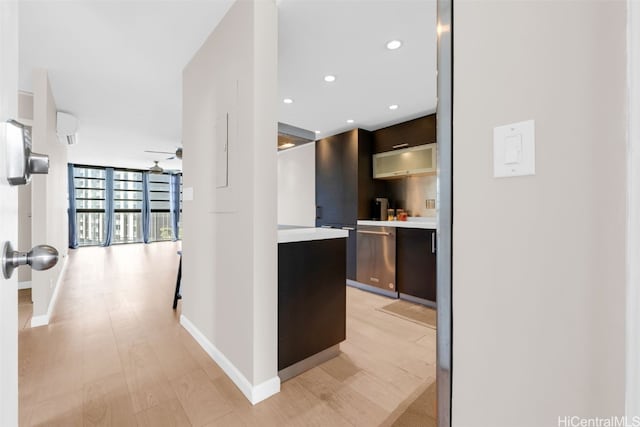 kitchen with floor to ceiling windows, stainless steel dishwasher, ceiling fan, light wood-type flooring, and dark brown cabinets