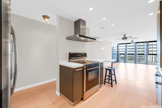 kitchen featuring floor to ceiling windows, ventilation hood, ceiling fan, range, and stainless steel refrigerator