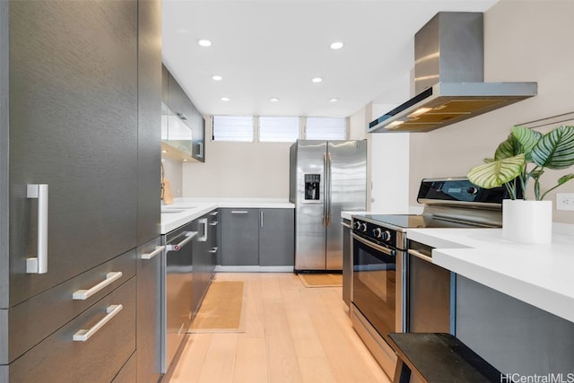 kitchen featuring sink, wall chimney exhaust hood, stainless steel appliances, and light wood-type flooring