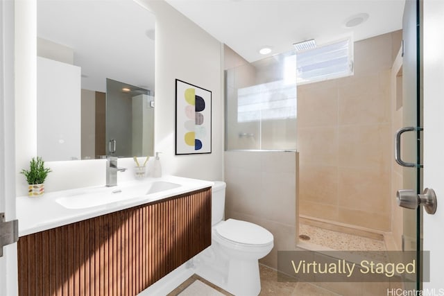 bathroom featuring vanity, toilet, and a shower with door