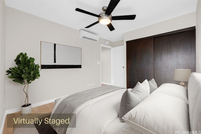 bedroom featuring ceiling fan, wood-type flooring, and a wall mounted AC