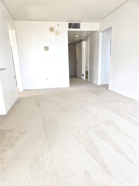 carpeted empty room featuring a textured ceiling