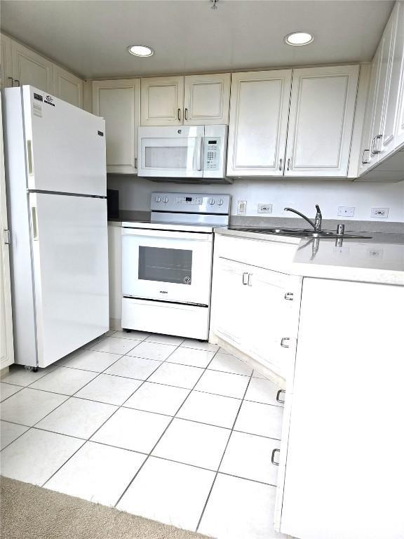 kitchen with sink, light tile patterned floors, and white appliances