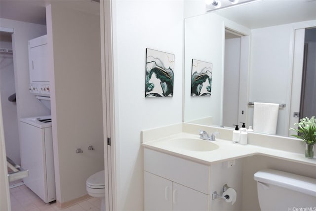 bathroom featuring toilet, stacked washer and dryer, and vanity