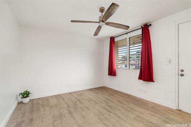 spare room with ceiling fan, light hardwood / wood-style floors, and a textured ceiling