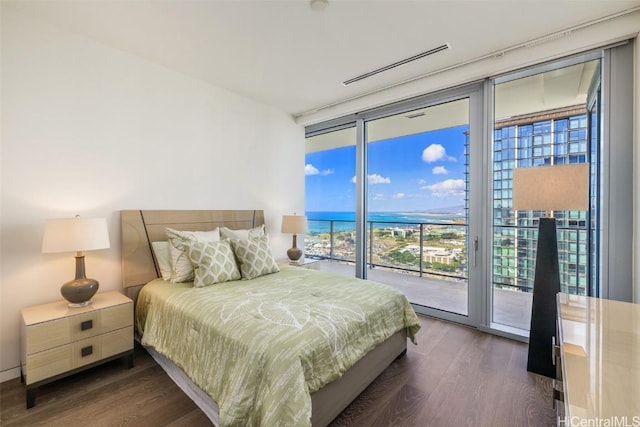 bedroom featuring access to outside, floor to ceiling windows, dark hardwood / wood-style flooring, and multiple windows