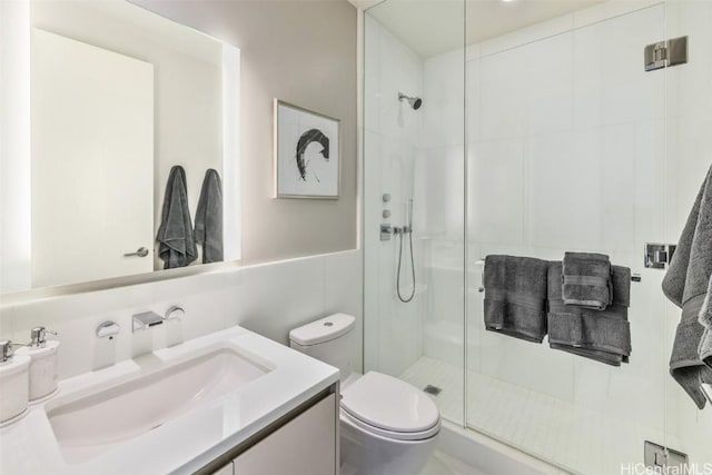 bathroom featuring vanity, a shower with door, toilet, tile walls, and tasteful backsplash