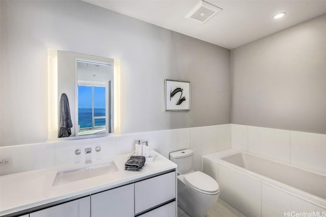 bathroom with tile patterned floors, vanity, toilet, and a bathtub