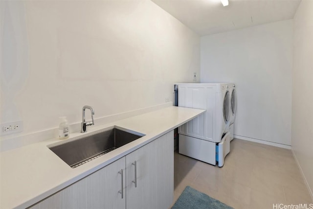 laundry room with sink, light tile patterned floors, cabinets, and independent washer and dryer