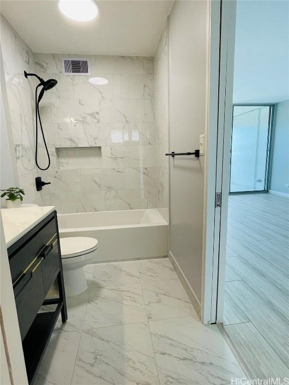 full bathroom with vanity, toilet, and tiled shower / bath